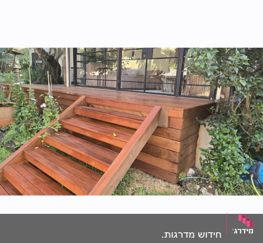 מדרגות עץ ליד גינה עם צמחים